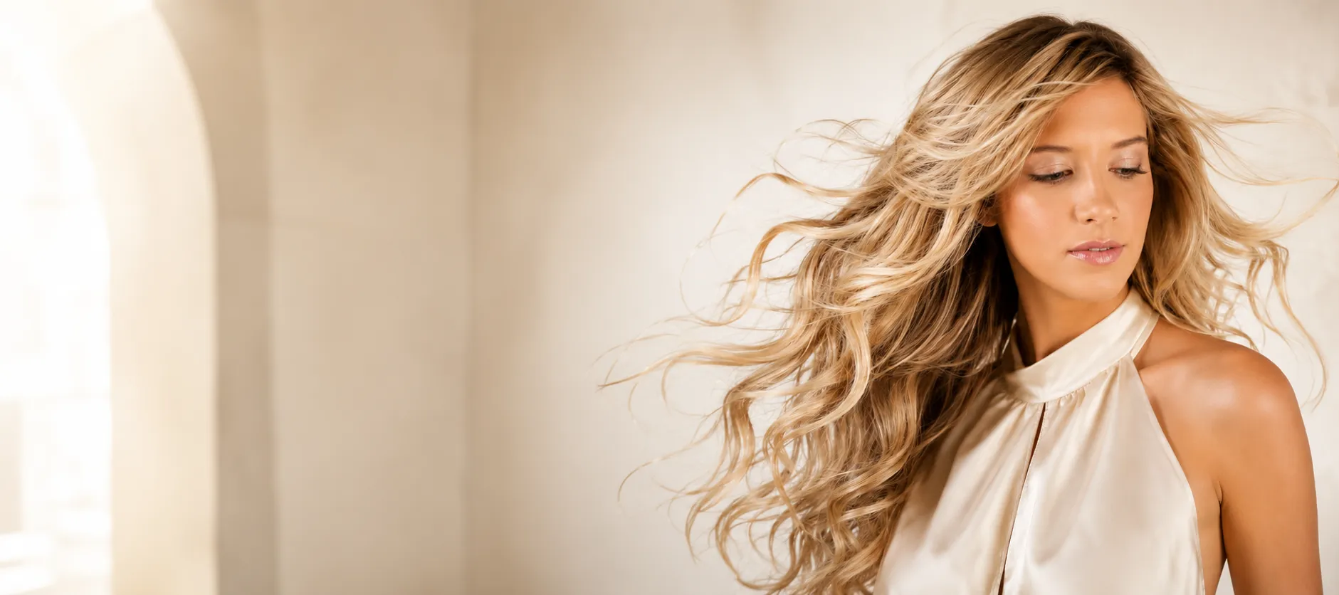 Model with long, softly waved hair in warm natural light