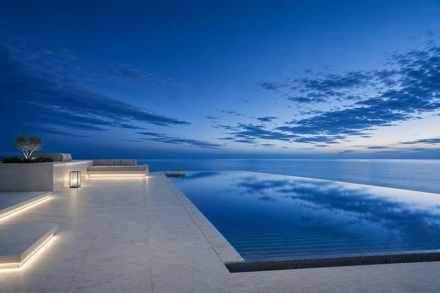 A minimal infinity pool terrace at dusk overlooking the sea